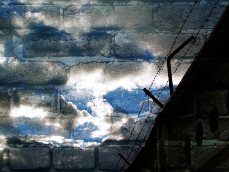 a barbed wire against background of a brick wall and cloudy sky