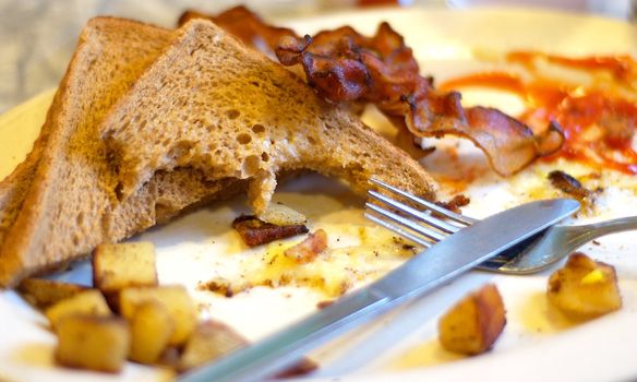 "Part of a complete breakfast" a play on words on the popular catchphrase with cereal commercials.  Home fries, toast, bacon and eggs.