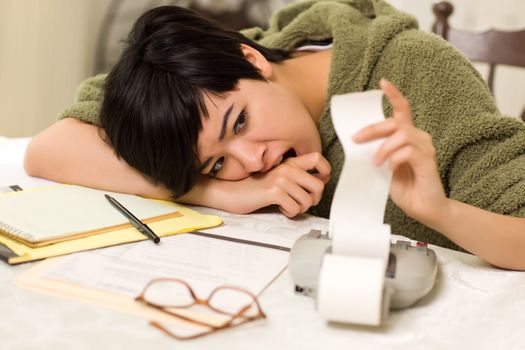 Multi-ethnic Young Woman Agonizing Over Financial Calculations in Her Kitchen.