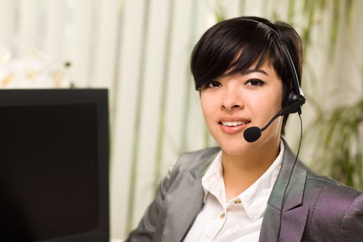 Attractive Young Woman Smiles Wearing Headset Near Her Computer Monitor.