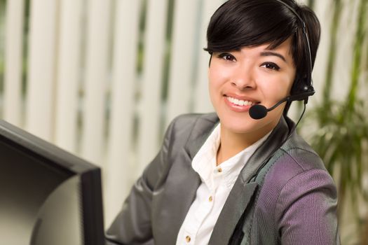 Attractive Young Woman Smiles Wearing Headset Near Her Computer Monitor.