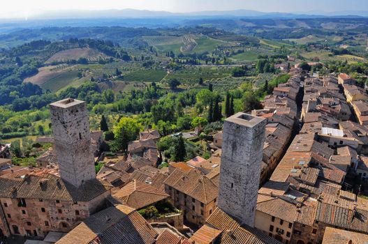 Tuscan village San Gimignano view from the tower, fields, meadows and vineyards in the background