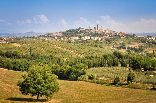 View of Tuscan village San Gimignano with fields, meadows and vineyards