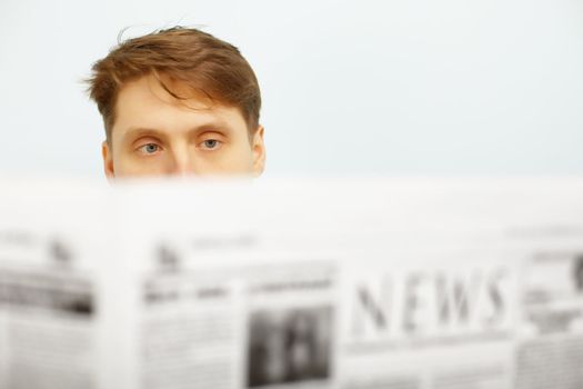 A young man reads the news in the newspaper