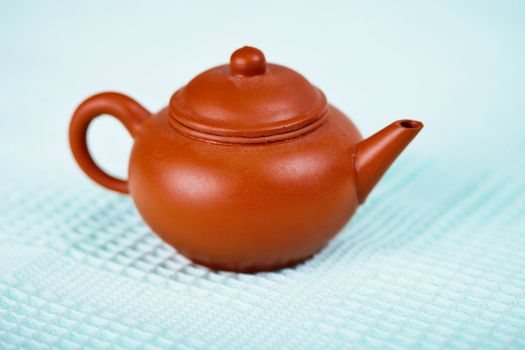 Old brown ceramic pot on a blue towel