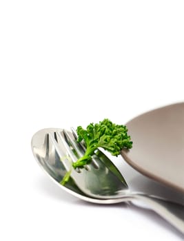 Parsley with fork and spoon isolated on a white background (with sample text)
