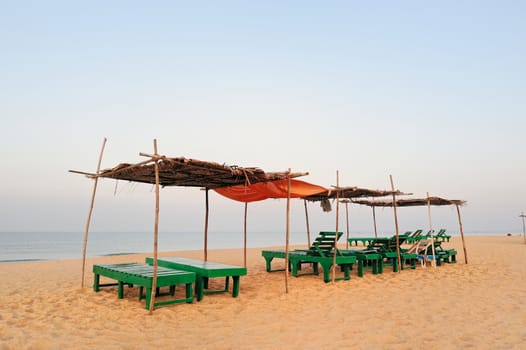 Exotic lean-tos of palm leaves on tropical beach