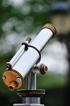 An tourist type telescope against the green trees