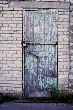 Weathered door of mine closed by old lock