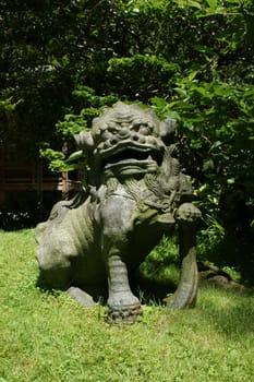 Stone statue of a lion in japanese garden