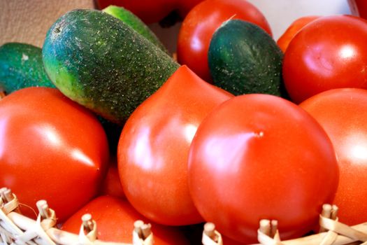 Zoomed foto of cucumber and tomatoes laying nearby