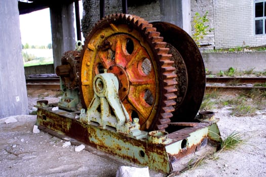 Old rusty mine shaft mechanism on dusty ground