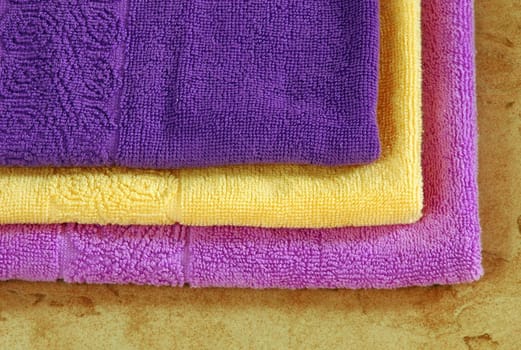 pile of colorful towels over brown background