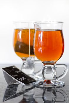 Teaglasses with tea on kitchen dresser by natural light - vertical and shallow dept of field