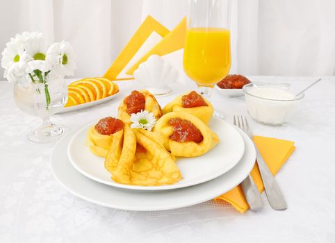 Breakfast with pancakes, apricot jam and orange juice