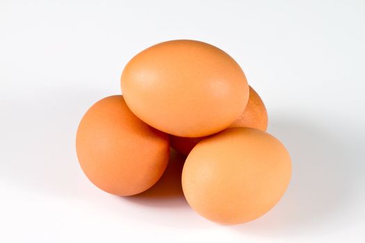 Four brown eggs arranged as a dolmen, isolated on white background