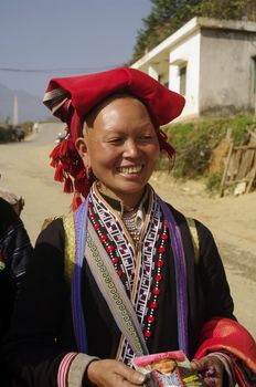 Woman of the ethnic (minority) Hmong red pompoms. This beautiful woman is the traditional clothing of his tribe and the headdress of married women. A basket in the back he used to transport vegetables to the house and contains the essential umbrella, which also serves to protect against the sun. The standard of beauty for women in Asia is to have white skin.