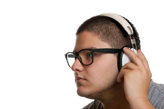 A young man listens to music with a set of head phones while examining the album cd case.