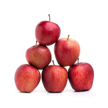 A pyramid of red delicious apples on a white background.