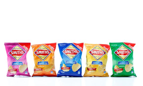 Five 45g packets of Smith's crinkle cut potato chips.  From left to right, Salt and Vinegar (924kj), Barbeque (941kj), Original (958kj), Cheese and Onion (945kj) and Chicken (939kj)   Smiths is owned by PepsiCo.  White Background.  Editorial Use Only.