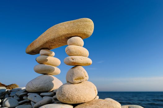 Long horizontal stone between a pebble piles