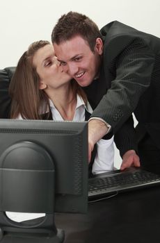Young office colleagues having fun in front of an office computer.