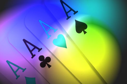 Abstract style close up of four ace playing cards with multicoloured light effect filter
