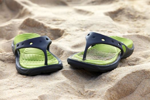 Female slippers on a coast of ocean