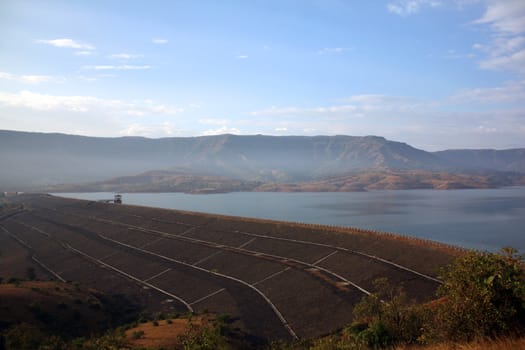 The structure of a dam in India, under blue skies.