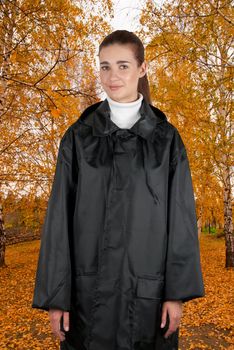 woman in rain coat walking at autumn forest