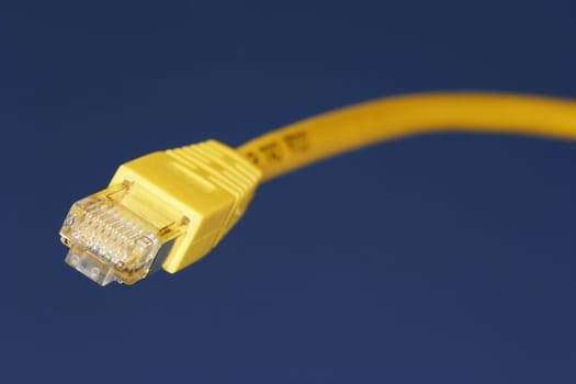 Yellow network cable against blue sky background