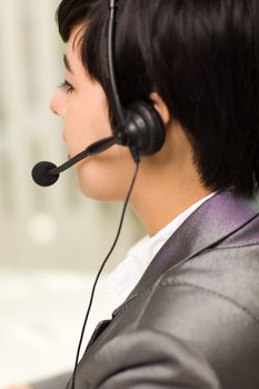 Profile of an Attractive Young Mixed Race Woman Smiles Wearing Headset In An Office Setting.