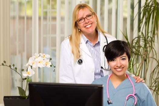 Smiling Mixed Race Female Doctors or Nurses Working Together in Office Setting.