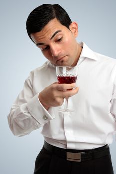 Professional man inspecting examining wine in a glass.