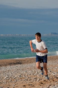 Teenager jogging early morning on a beach