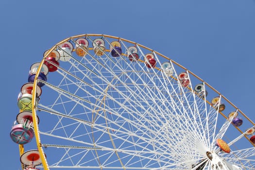 Ferris wheel in an amusement park against blue sky
