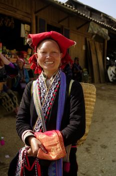Woman of the ethnic (minority) Hmong red pompoms. This beautiful woman is the traditional clothing of his tribe and the headdress of married women. A basket in the back he used to transport vegetables to the house and contains the essential umbrella, which also serves to protect against the sun. The standard of beauty for women in Asia is to have white skin.