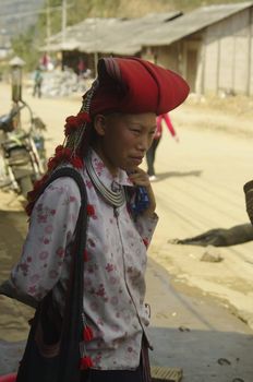 Woman of the ethnic (minority) Hmong red pompoms. This beautiful woman is the traditional clothing of his tribe and the headdress of married women. The standard of beauty for women in Asia is to have white skin.