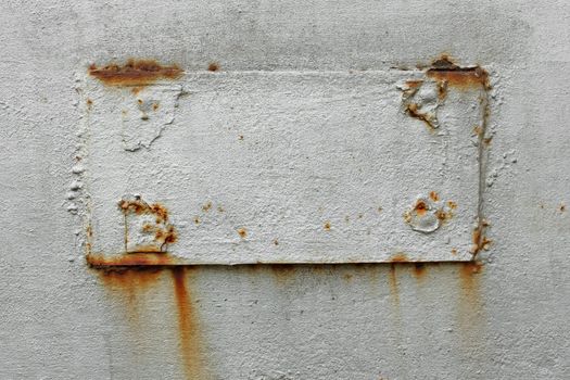 Fragment of old metal surface with welded rectangular patch. Dyed in silver color