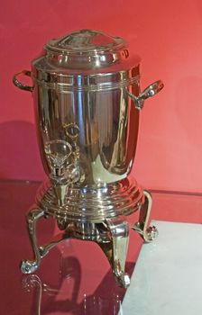 Old tea dispenser over a red background