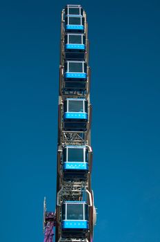 ferris wheel at amusement park against great blue sky