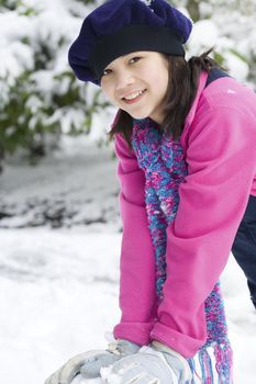 Beautiful twelve year old girl playing in the snow in winter