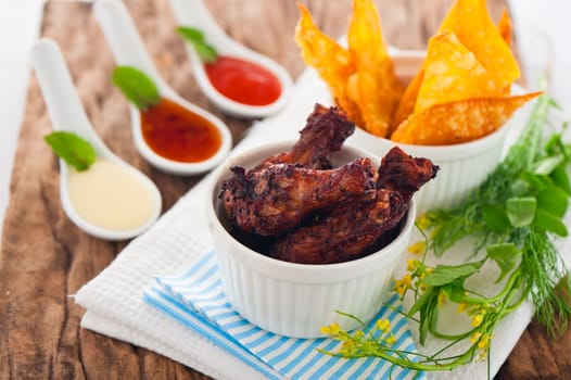 chicken legs with different sauces and chips