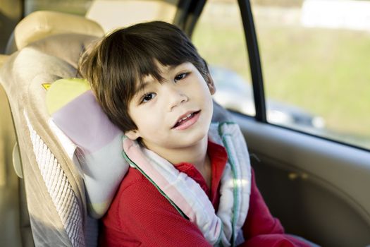 Four year old boy with cerebral palsy sitting in carseat