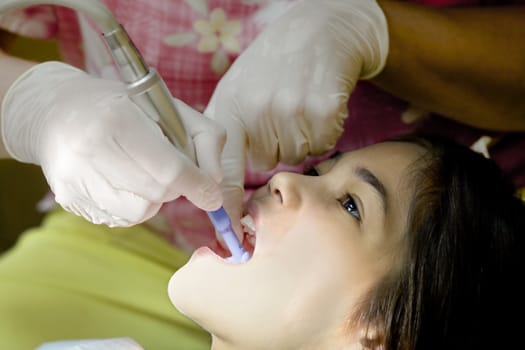 Little girl having teeth cleaned at dental office