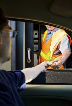 Man paying money at toll booth