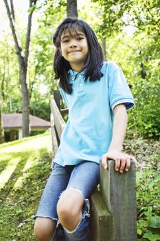 Little girl sitting on fence