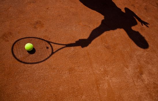 shadow of a tennis player in action on a tennis court