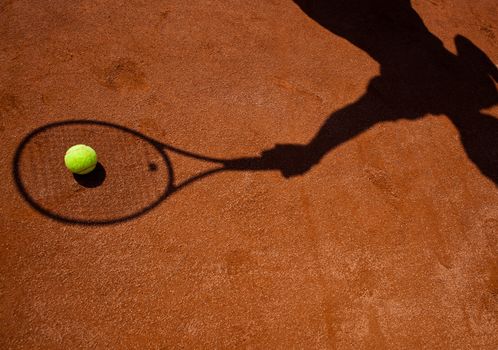 shadow of a tennis player in action on a tennis court