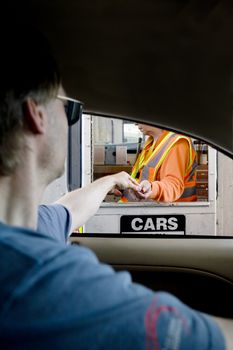 Man paying moneyl at toll booth